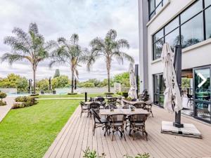 a patio with a bunch of tables and chairs at Cosy Regency menylin apartment in Pretoria