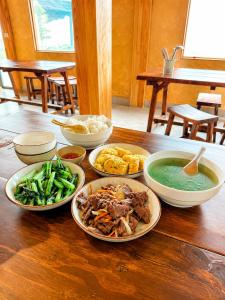 a table with plates of food and bowls of soup at Samu Retreat Tà Xùa in Bắc Yên