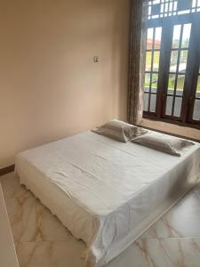 a bed sitting in a room with a window at Neem Homestay in Hatton