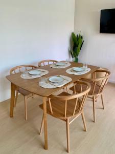 a wooden table with chairs and plates on it at The Town Pool Villas in Krabi