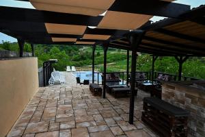 a patio with tables and chairs under a roof at RA Apartmani Vrdnik in Vrdnik