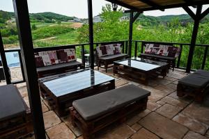 a patio with tables and chairs and a view of the mountains at RA Apartmani Vrdnik in Vrdnik