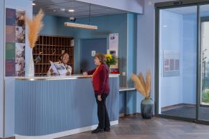 a woman standing in front of a counter at DOMITYS - Les Canotiers in Argenteuil