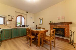 a kitchen with a table and chairs and a fireplace at Spacious home near Orta, 8min in Armeno +37 photos
