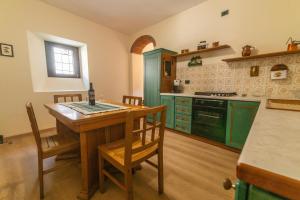 a kitchen with green cabinets and a table and chairs at Spacious home near Orta, 8min in Armeno