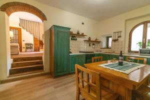 a kitchen with green cabinets and a wooden table at Spacious home near Orta, 8min in Armeno