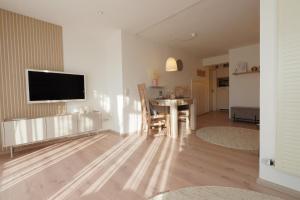 a living room with a table and a television on a wall at Dahoam beim Haas in Rieden