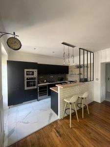 a kitchen with black and white appliances and two chairs at Le Rennes Gare in Rennes