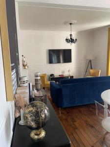 a living room with a blue couch and a table at Le Rennes Gare in Rennes