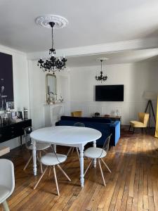 a living room with a white table and a blue couch at Le Rennes Gare in Rennes +1 photo