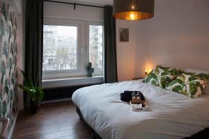 a room with a bed with a bag and a window at Stylish Central Flat, Steps to Beach in Ostend
