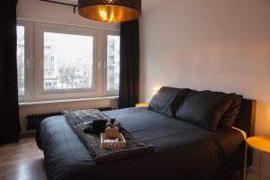 a bedroom with a bed with a tray on it at Stylish Central Flat, Steps to Beach in Ostend