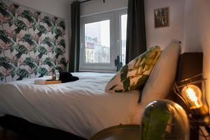 a bedroom with a large bed with a window at Stylish Central Flat, Steps to Beach in Ostend +26 photos
