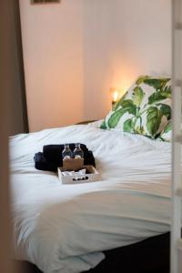 a white bed with two bottles on top of it at Stylish Central Flat, Steps to Beach in Ostend