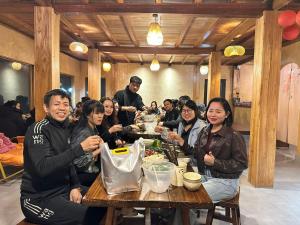 a group of people sitting at a table eating food at Samu Retreat Tà Xùa in Bắc Yên