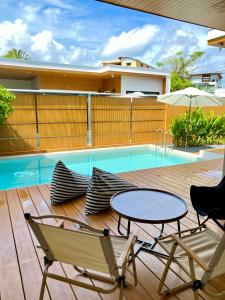 a patio with a table and chairs and a pool at The Town Pool Villas in Krabi
