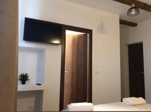 a bedroom with a closet with a television on the wall at Vila Francisca10 in Alba Iulia