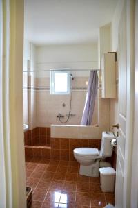 a bathroom with a toilet and a tub and a sink at La SyRosA in Vári +22 photos
