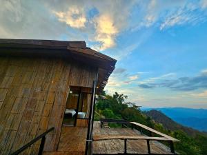 a wooden building with a balcony on a mountain at Mon Ngo misty haven B2 in Ban Mae Ta Man