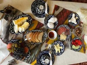 a table with plates of food on a table at Abubakir Guests House in Samarkand