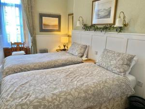 a hotel room with two beds and a window at Simply the best ! 4 Min walk to Beach, Pubs, Restaurants, Shops, Heated Pool, Hottub, Games room, 1 acre Garden, BBQ's, Private Parking, WIFI, Basesets acre, call for other dates ! in Portreath +22 photos