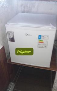 a white cooler sitting on a shelf with a sticker on it at Suite Love in Paty do Alferes
