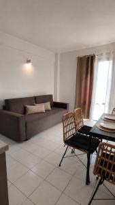 a living room with a couch and a table and chairs at Filoxenia in Platy