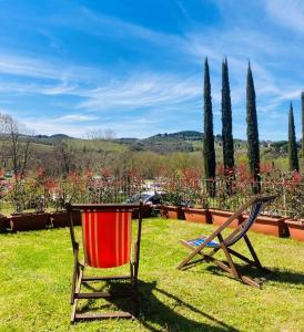 a chair and a table in the grass at Cipressi Rossi in Greve in Chianti