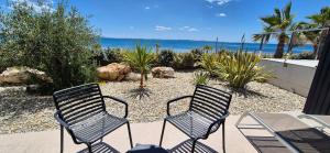 two chairs sitting on a patio overlooking the ocean at Dinary Deluxe Apartments in Vir +68 photos