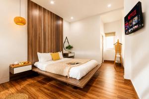 a bedroom with a bed with a wooden headboard at The Morris Central Hotel - O'TEL in Da Lat +23 photos