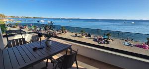 a balcony with a table and a beach with people at Dinary Deluxe Apartments in Vir