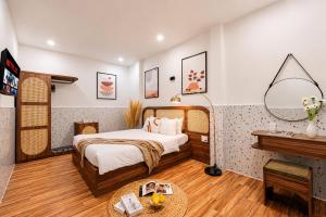 a hotel room with a bed and a table at The Morris Central Hotel - O'TEL in Da Lat