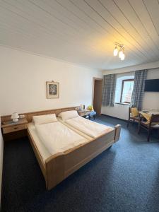 a bedroom with a large bed and a table at Gästehaus Valentina in Mayrhofen