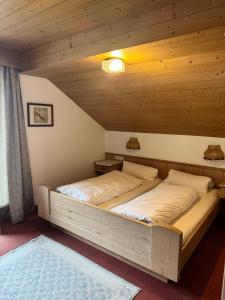 a bed in a room with a wooden ceiling at Gästehaus Valentina in Mayrhofen