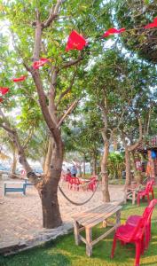 a park with red chairs and a bench next to a tree at Hoa Bien Motel in Ly Son