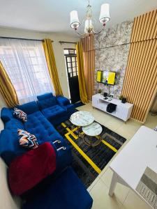 a living room with a blue couch and a tv at ONE BEDROOM THIKA ROAD ,TRM DRIVE Homes by Essyruby in Nairobi