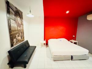 a bedroom with a bed and a red wall at Sino @ Thungsong in Thung Song