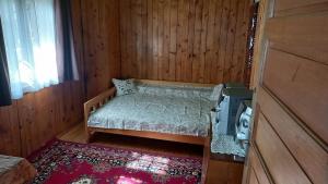 a small bedroom with a bed in a wooden room at Casa Wylak Winery in Uileacu de Criş