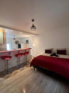 a bedroom with a bed and two red bar stools at L'Essentiel de Paray in Paray-le-Monial