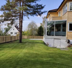 a backyard with a tree and a house at Spacious Villa in Lillehammer in Lillehammer
