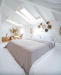 a bedroom with a large bed in a white room at Kurabiye Hotel in Alaçatı