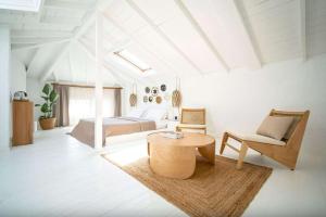a bedroom with a bed and a table and a chair at Kurabiye Hotel in Alaçatı