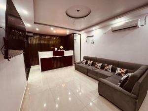 a living room with a couch and a bar at The Aura Grand Hotel and Cafe in Patna