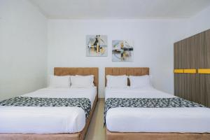 two beds sitting next to each other in a room at The Lavana Signature Villa Herrera Puncak in Puncak +24 photos