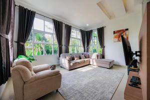 a living room with two couches and a large window at The Lavana Signature Villa Herrera Puncak in Puncak