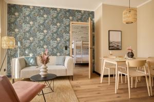 a living room with a couch and a table at Gezeiten Suites Büsum - Neueröffnung in Büsum
