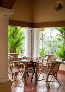 a dining room with chairs and a table and a window at Villa Mariam in Cheruvalli