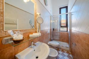 a bathroom with a sink and a toilet and a mirror at Hotel Virginia in Marina di Massa