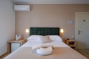 a bedroom with a large bed with a green headboard at Hotel Virginia in Marina di Massa +70 photos