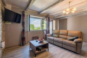 a living room with a couch and a table at Gîte Les Sapins Douglas in Sansac-Veinazés